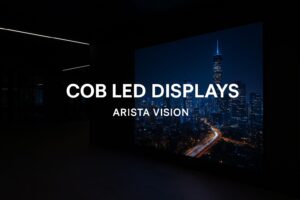 commercial space with a large COB LED display showing a city skyline at night, featuring the text "COB LED Displays — Arista Vision" in bold white letters.